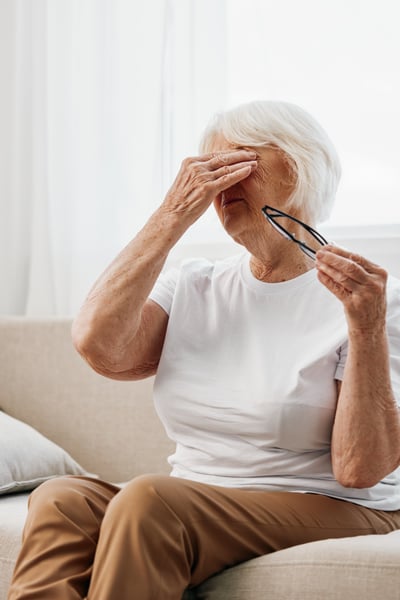 elderly-woman-severe-eye-pain-sitting-on-the-couch-2024-02-13-18-18-23-utc